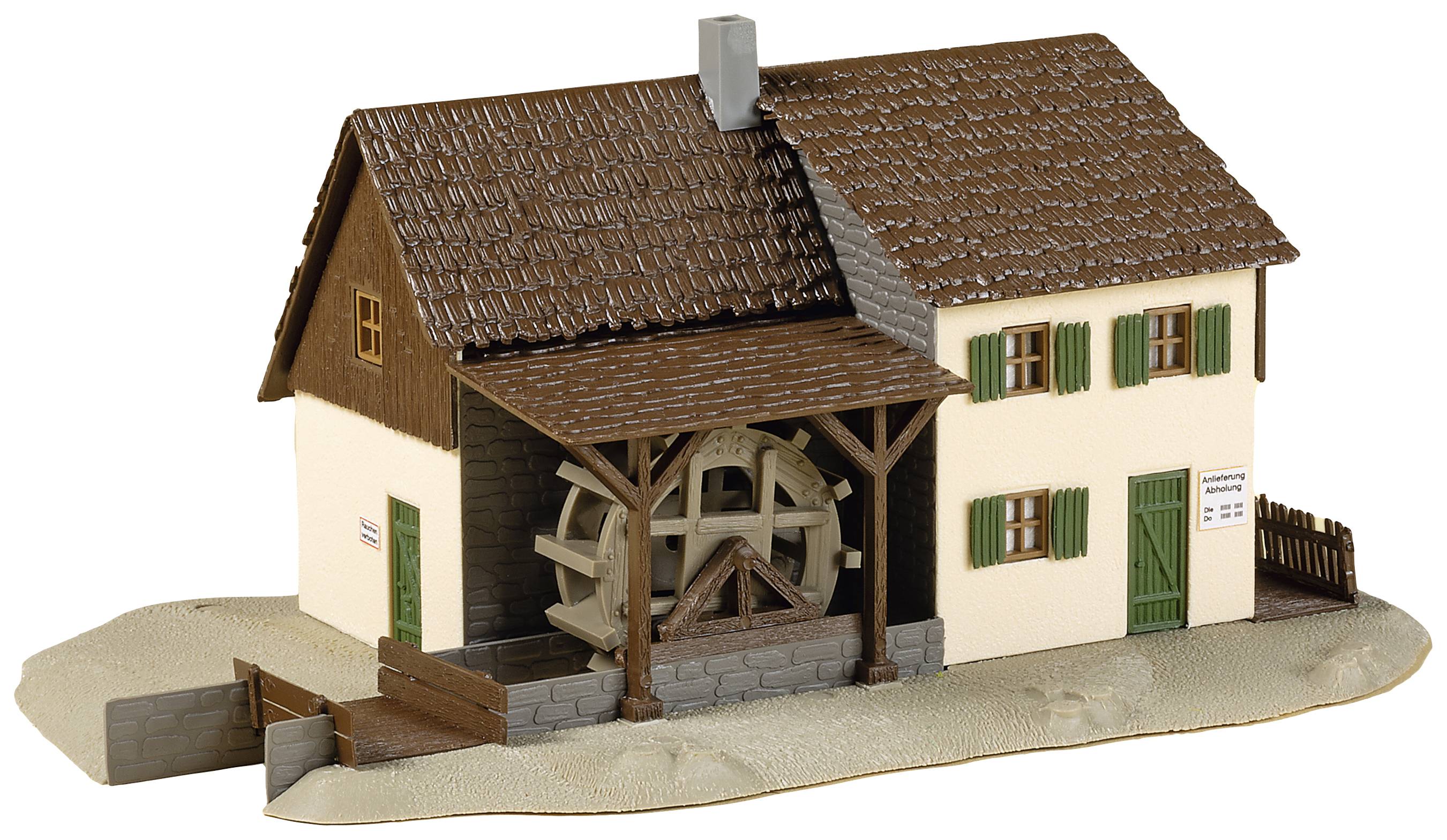 Model tradičního domu s vodním kolem. Detail budovy s komínem a zelenými okenicemi. Dům stojí na malém podstavci.