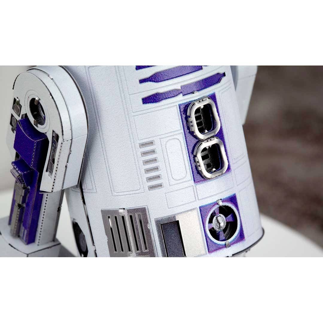 Detailní záběr bílého a modrého robotického modelu s viditelnými otvory a přípojnými zdířkami na jeho těle.
