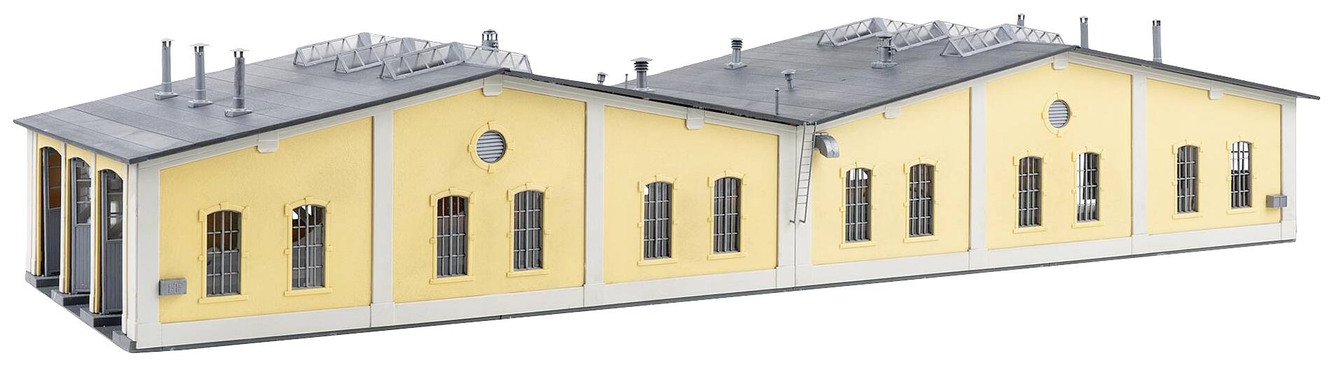 Žlutá budova ve stylu průmyslového areálu s několika komíny a velkými okny, vhodná pro modelářství nebo architektonický design.