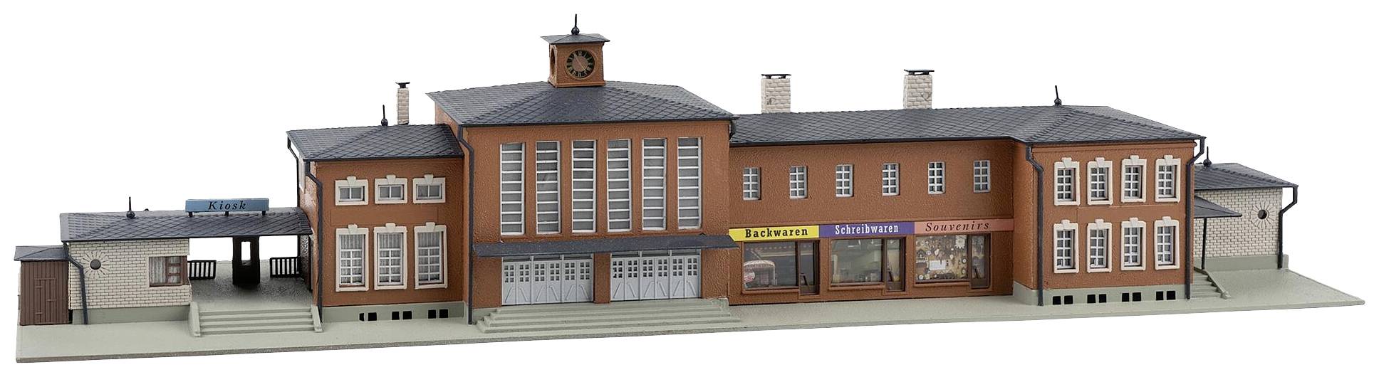 Model nádražní budovy z červených cihel s hodinovskou věží a výlohami. Detaily jako schodiště a cedule jsou jasně patrné.