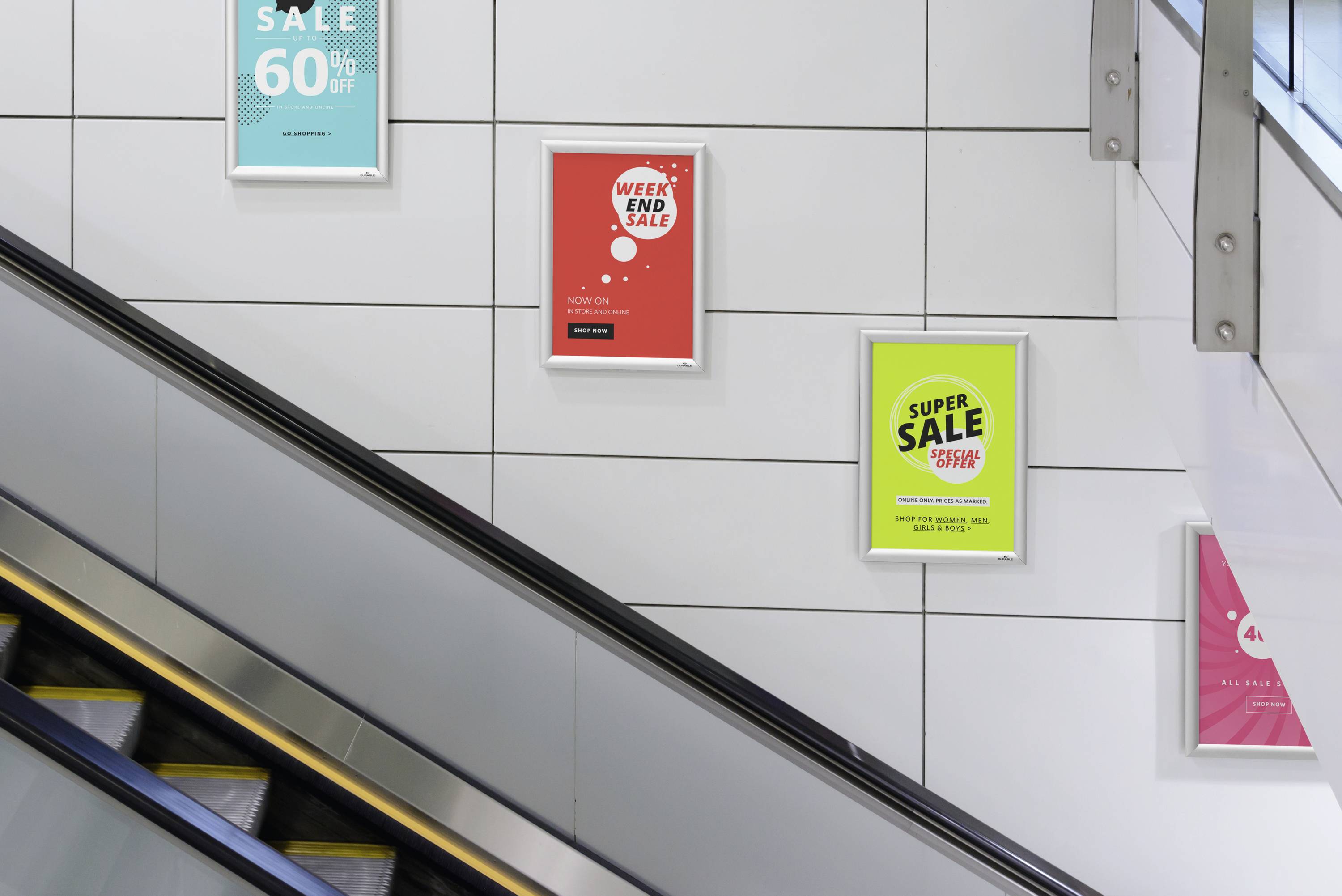 Čtyři reklamní plakáty visí na stěně podél pohyblivého schodiště: 'VÝPRODEJ 60%', 'VÍKENDOVÝ VÝPRODEJ 20%', 'SUPER VÝPRODEJ 50%', '4-NÁSOBEK'.