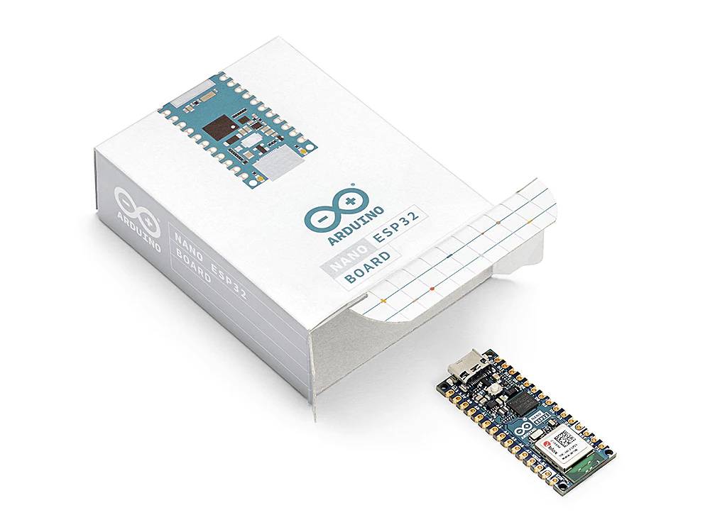 Arduino Nano ESP32 deska leží vedle otevřené krabičky od produktu. Grafika na krabičce zobrazuje stejnou součástku.