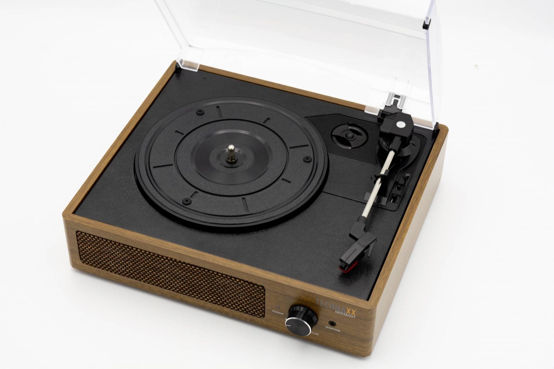 Gramofon s dřevěným rámem a průhledným krytem, černým talířem a ramenem pro snímání zvuku; otočný ovladač na přední straně.