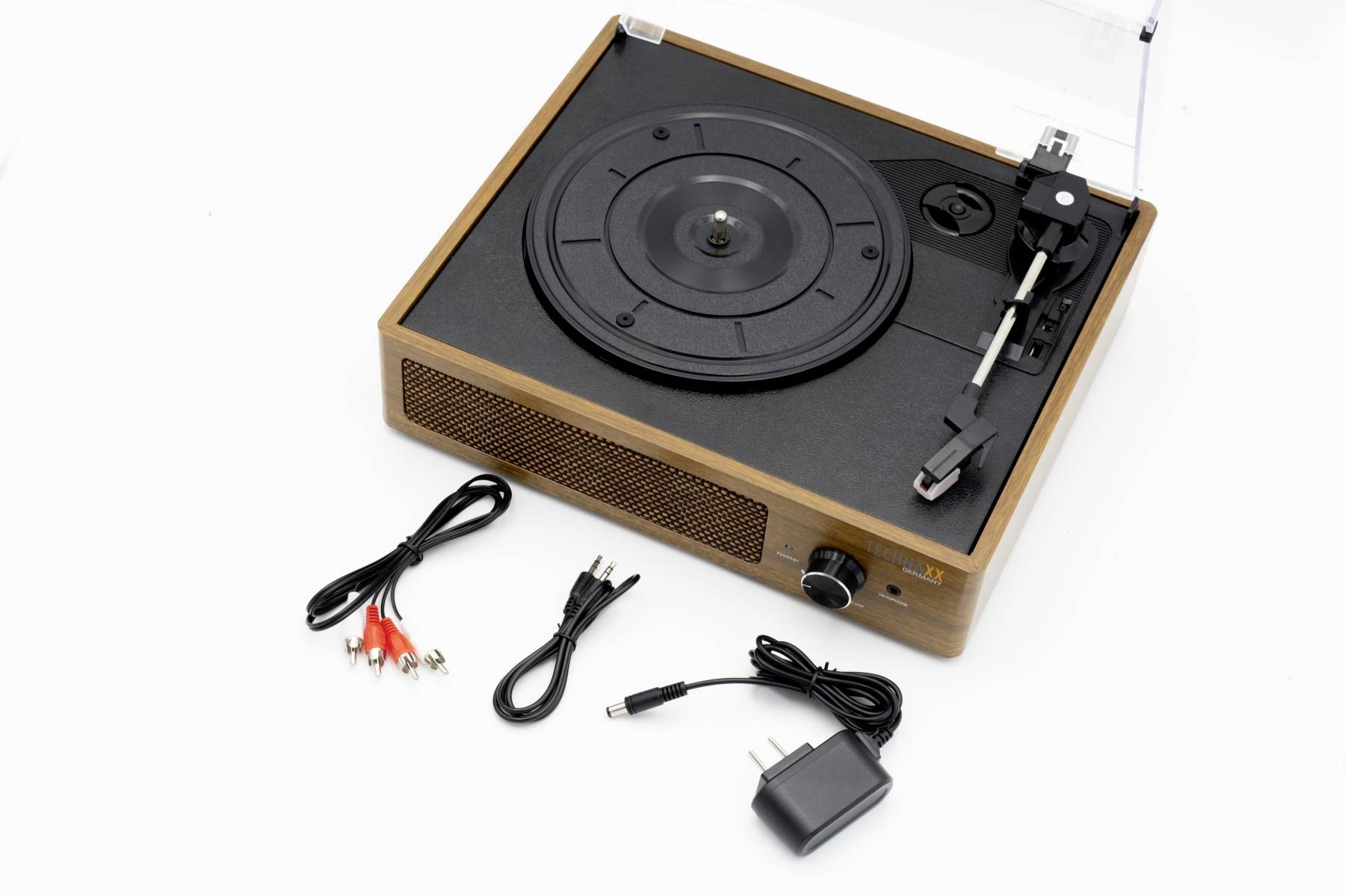 Gramofon s designem dřevěné kostky, po straně reproduktory, vedle kabel a napájecí adaptér, připravený k připojení a použití.