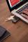 Ruka používá notebook s připojeným USB flash diskem spolu se svazkem klíčů.