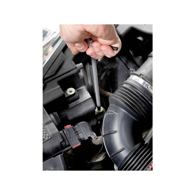 Jedna osoba používá šroubovák k upevnění šroubu v motorovém prostoru automobilu.