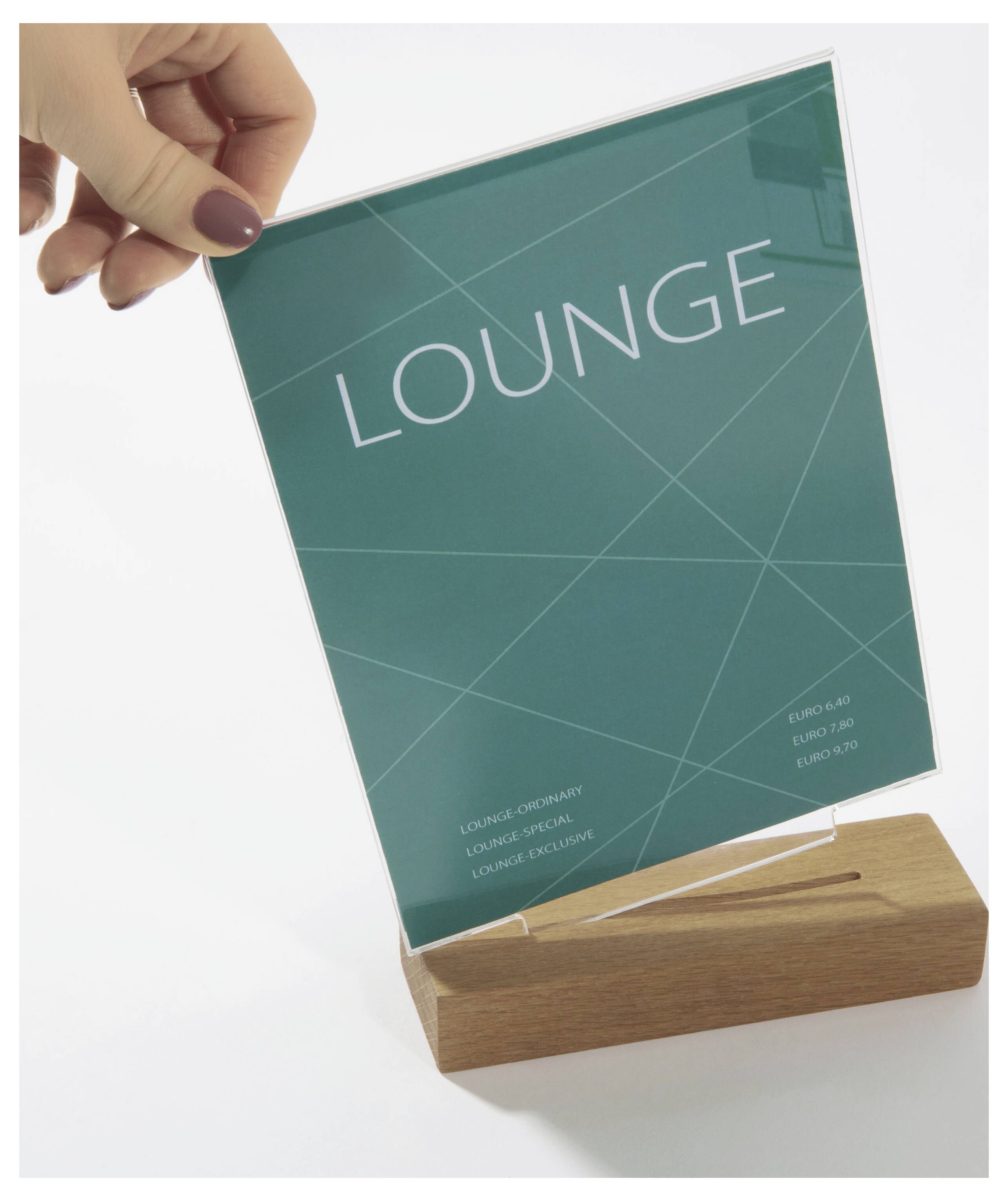 Ruka držící tyrkysovou ceduli s nápisem "LOUNGE" v dřevěném stojanu na bílém pozadí.
