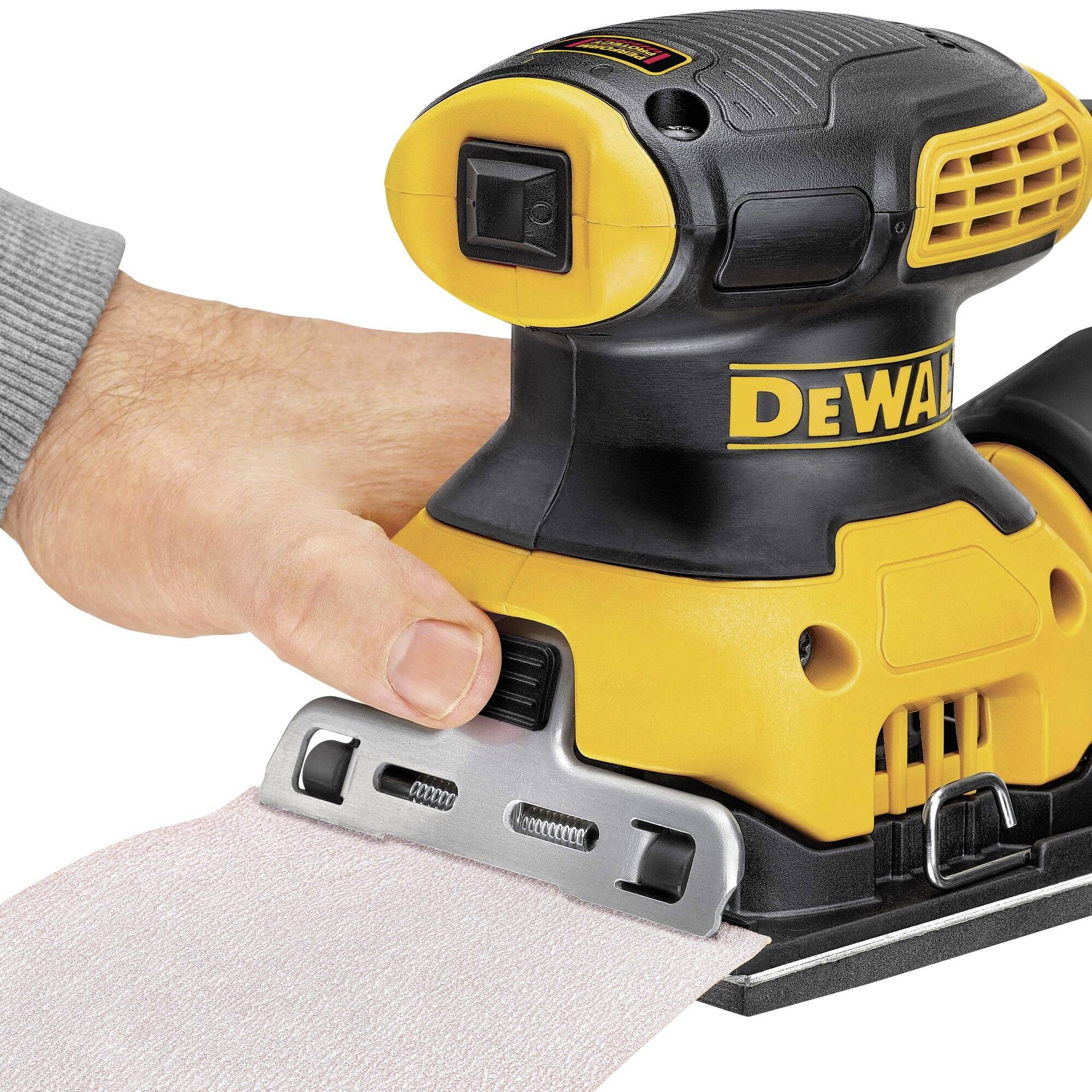 Ruka drží elektrické brusné zařízení na kovovém povrchu, připravena k opracování.