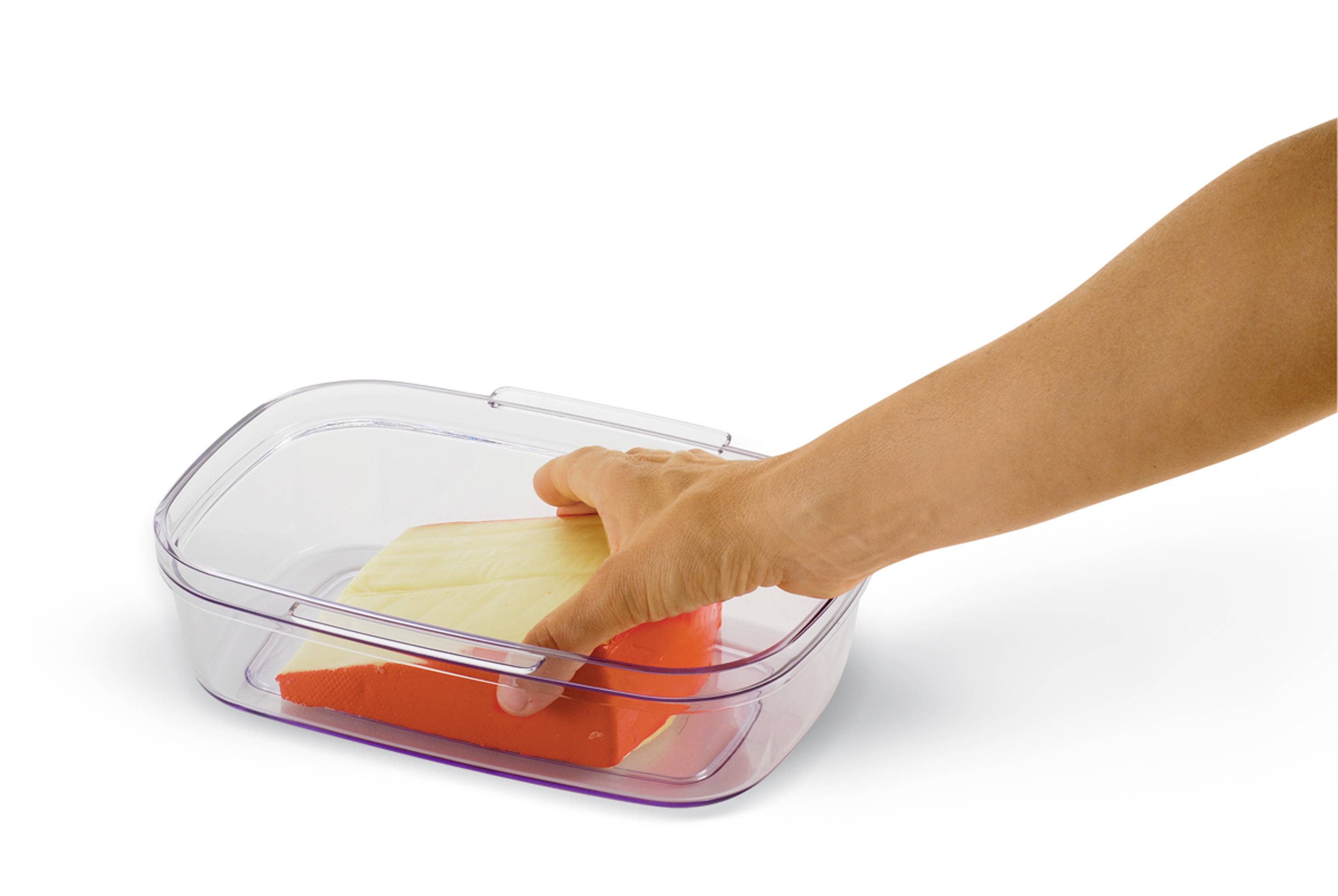 Ruka klade dva trojúhelníkové houby s odlišnou barvou do průhledné nádoby.