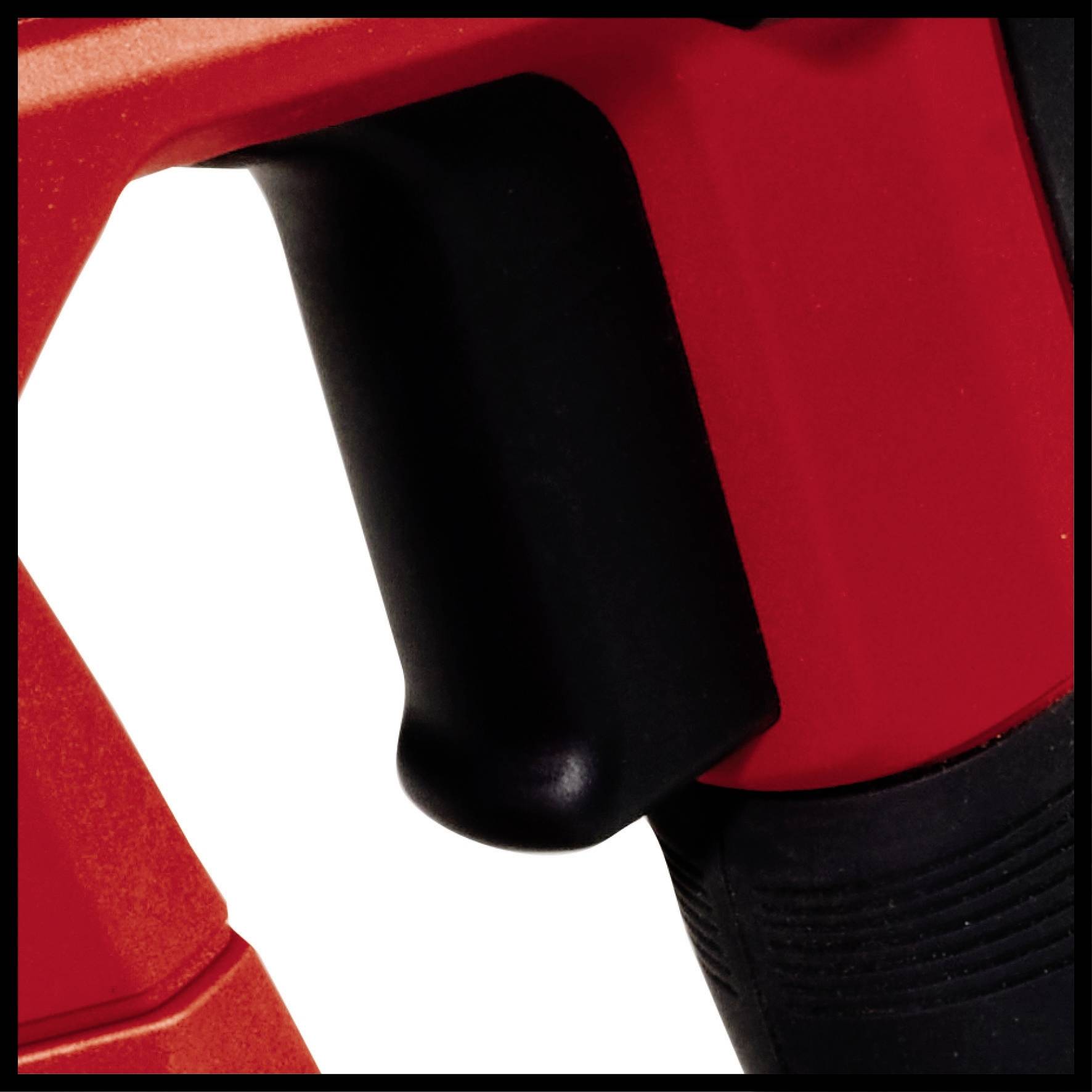 Detailní záběr černé rukojeti na červeném nástroji, který ukazuje ergonomii a strukturu materiálu.