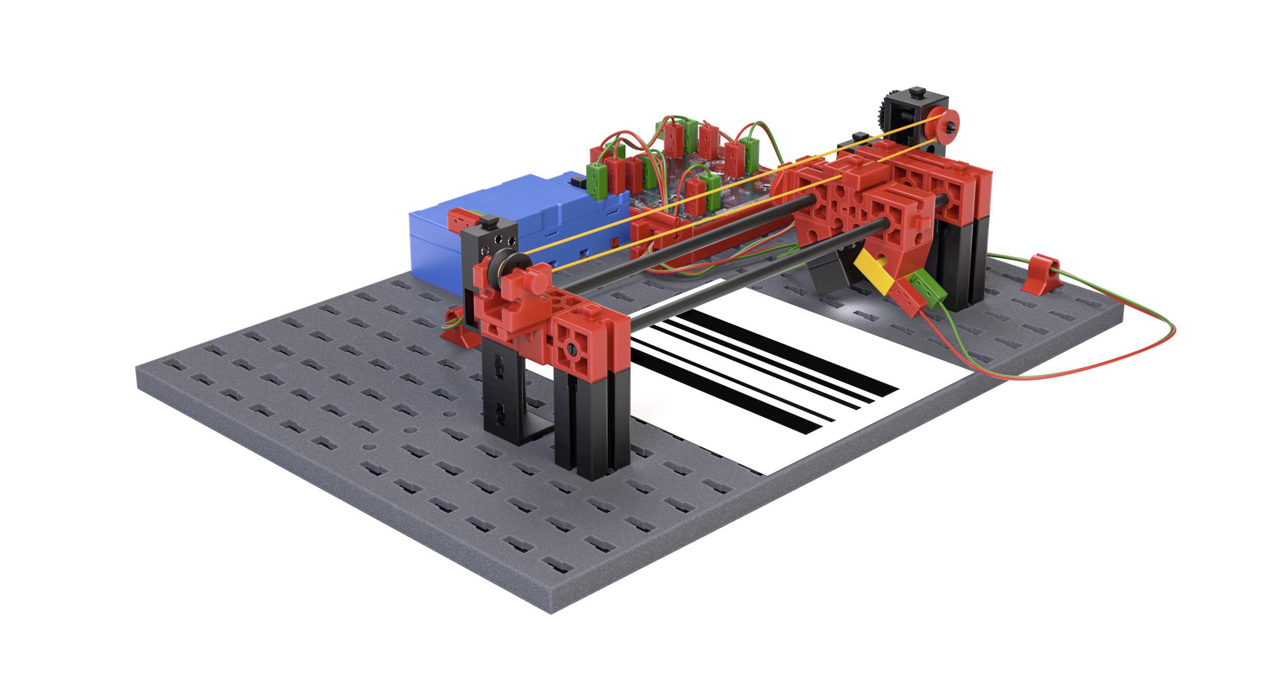 Mechanické zařízení z červených součástí s dráty a ozubenými koly, které přesně vykresluje linky na papíře, pravděpodobně se jedná o ploter.
