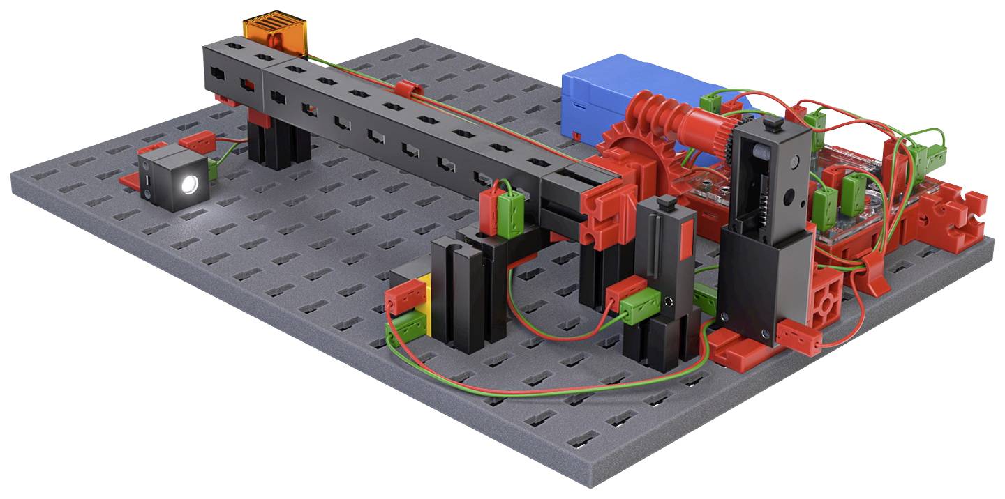 Model mechanického zdvihového systému s červenými a černými komponenty na šedé základní desce. Dráty jsou propojené.