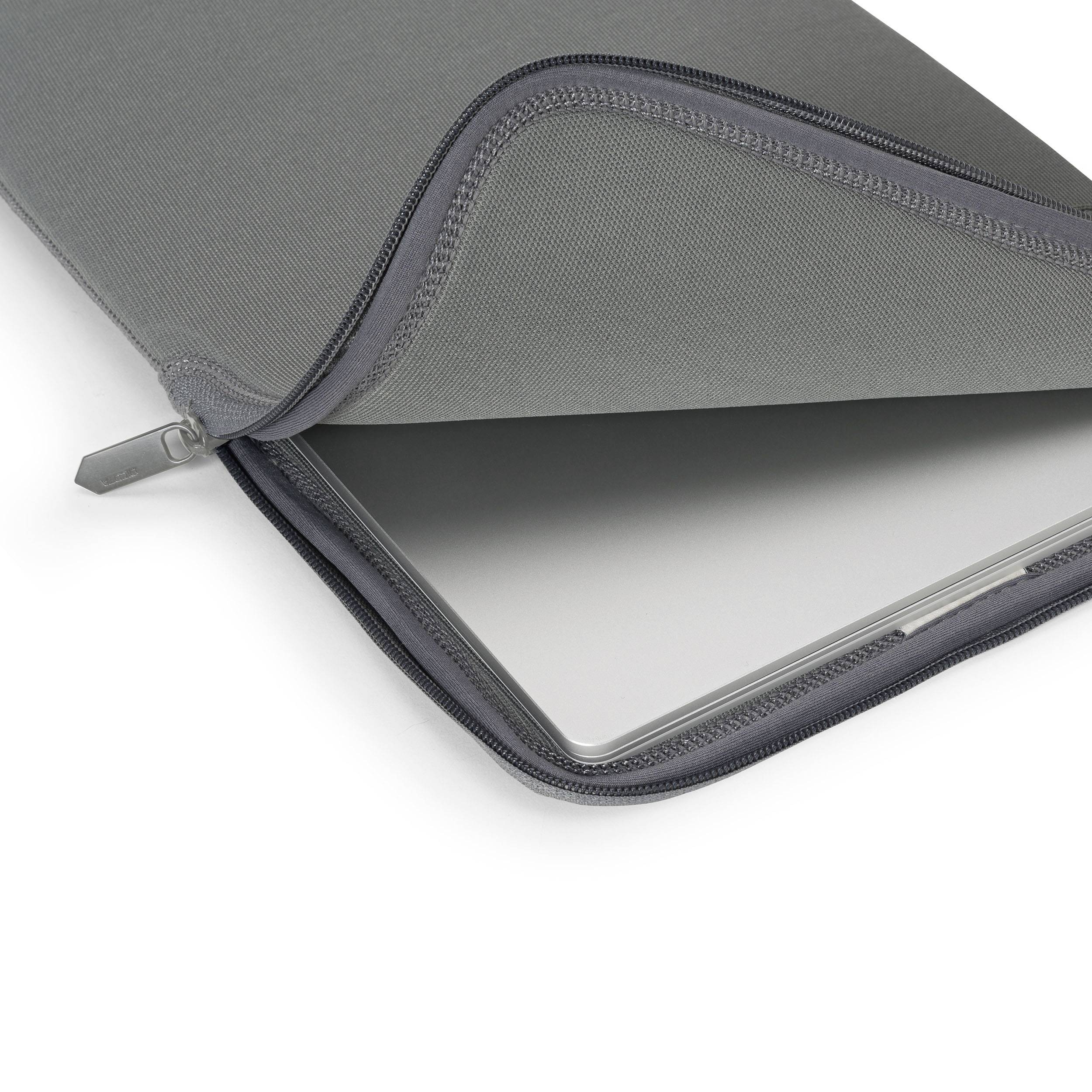 Notebook v šedém ochranném obalu, který je lehce otevřený, takže je zařízení viditelné. Obal je vyroben z měkkého, matného materiálu.