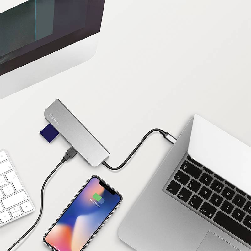 Notebook a smartphone jsou připojeny k USB rozbočovači, který také ukazuje připojení paměťové karty. Technologické nastavení.
