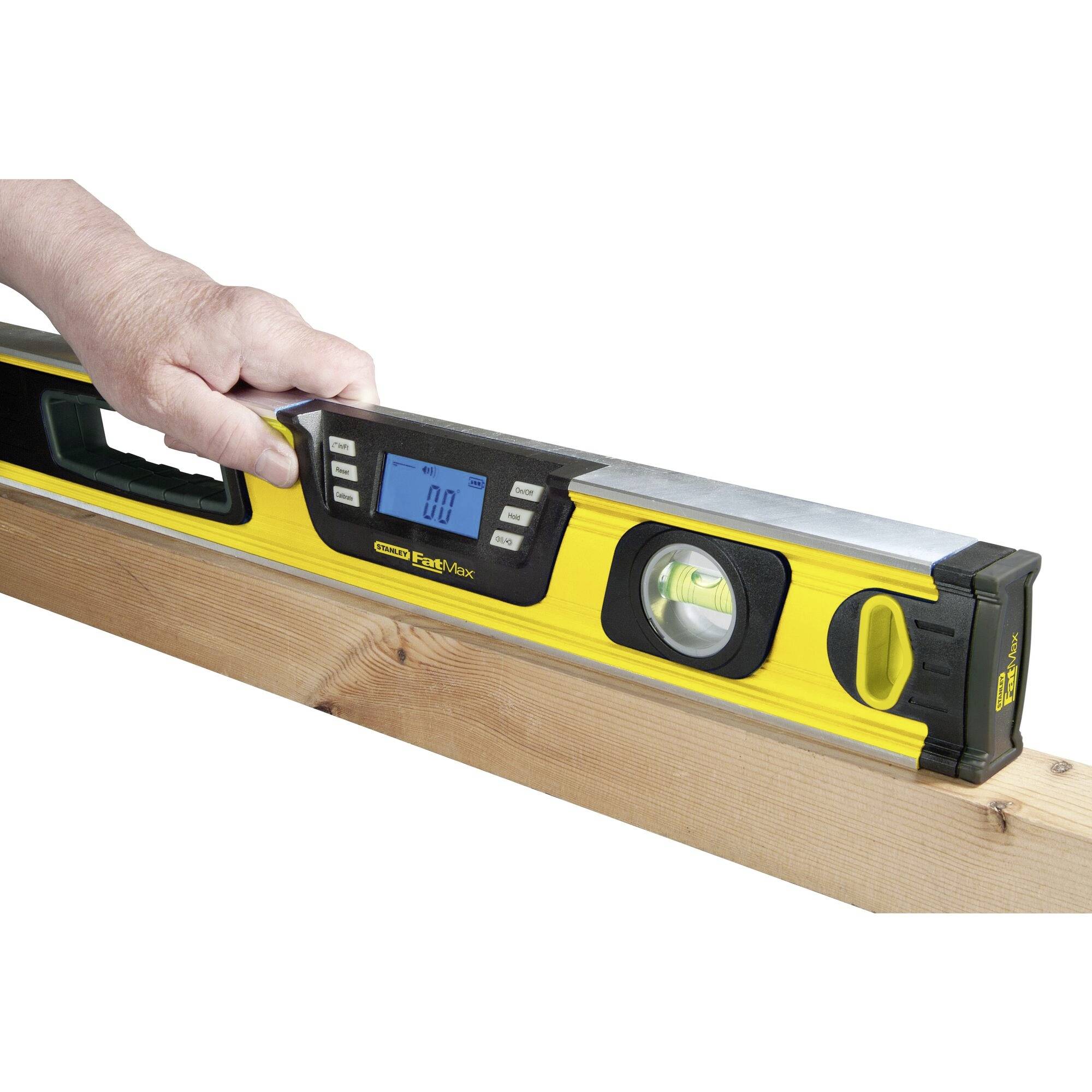 Jedna osoba drží žlutou digitální vodováhu položenou na dřevěné desce. Displej zobrazuje naměřenou hodnotu.