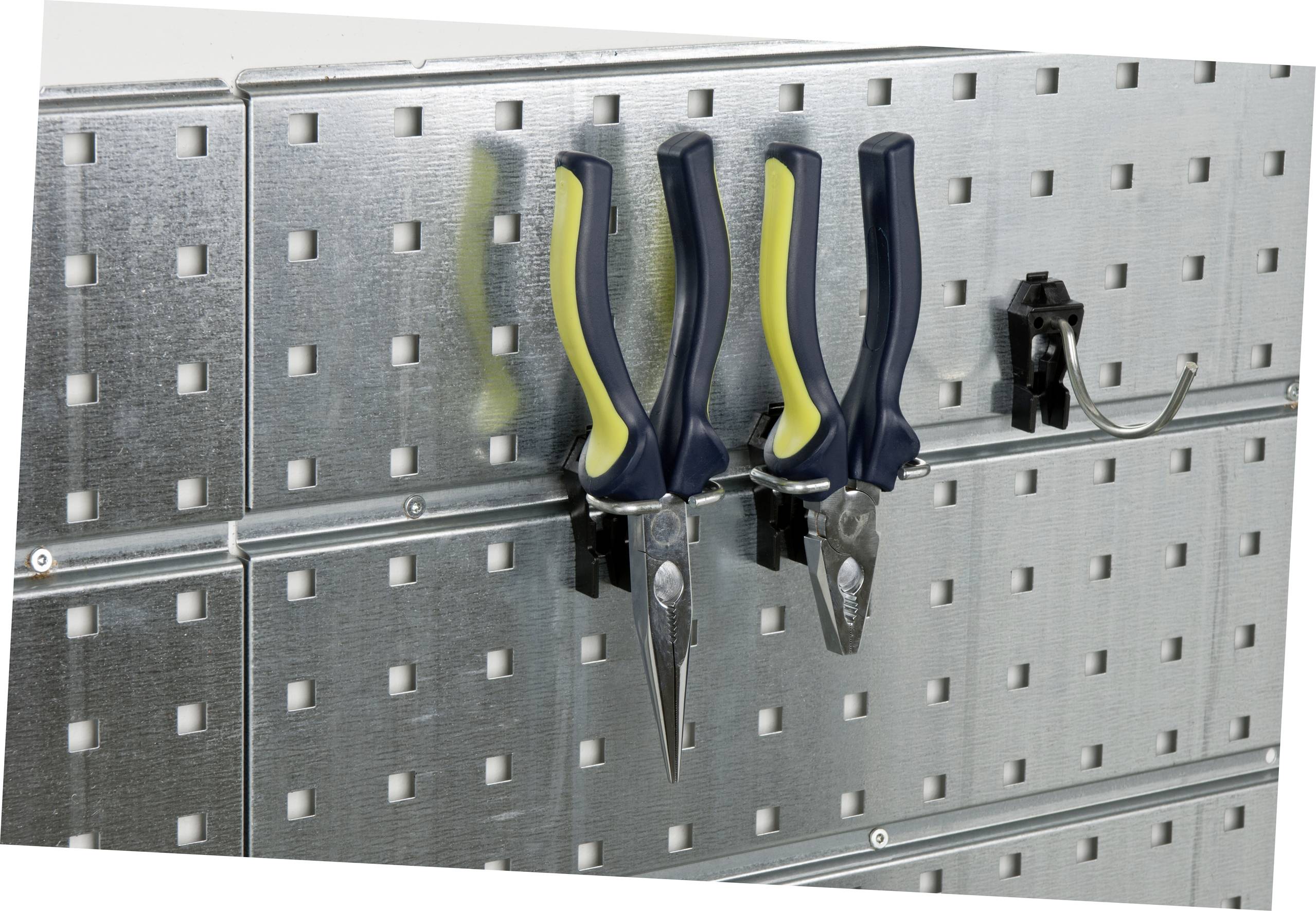 Dvě kleště s černo-žlutými rukojeťmi visí na děrované desce na stěně. Vedle nich je prázdný upevňovací prvek.