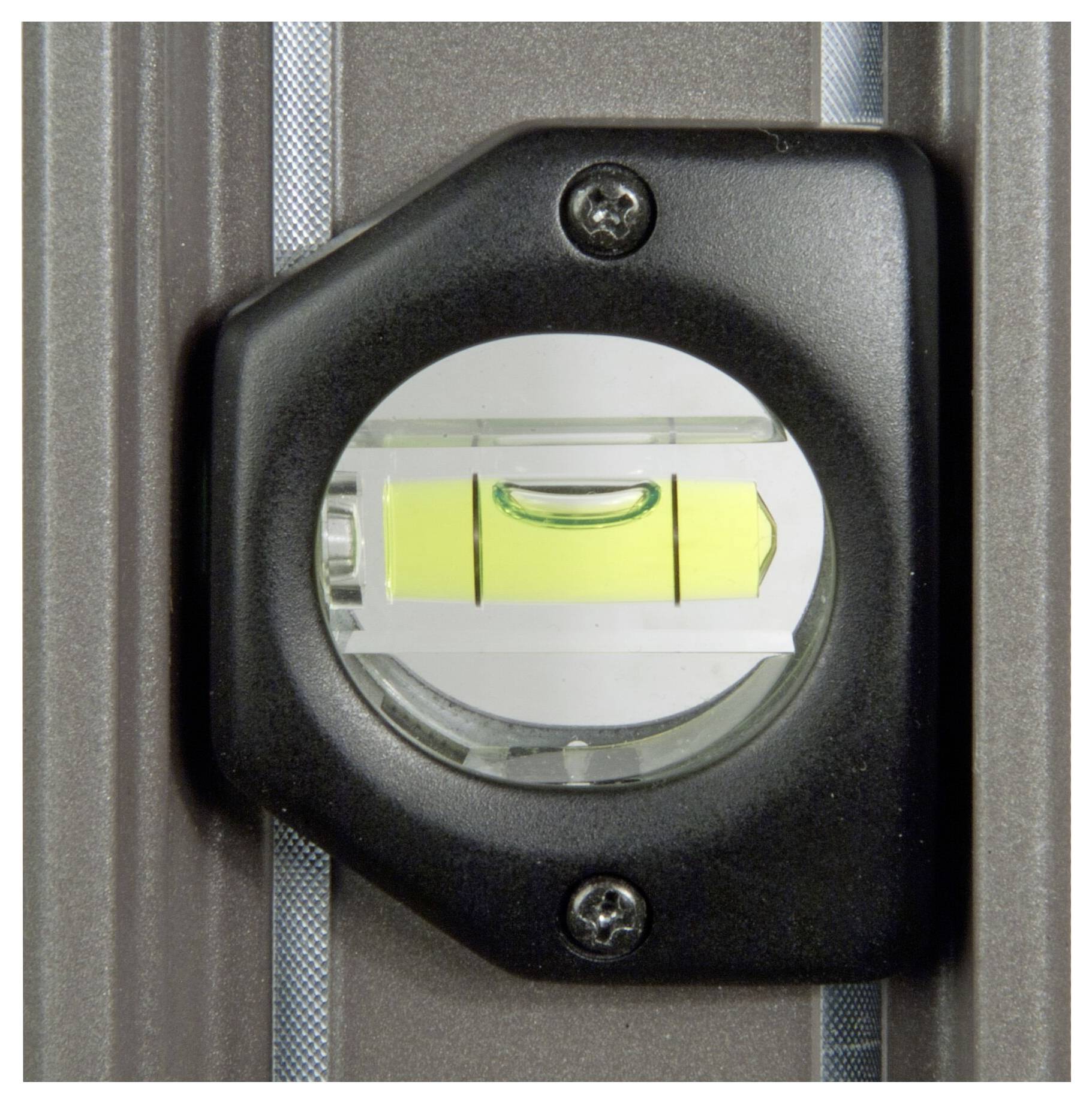 Vodováha v držáku ukazuje nazelenalou kapalinu s bublinkou vzduchu, která se vznáší přesně uprostřed mezi dvěma značkami.