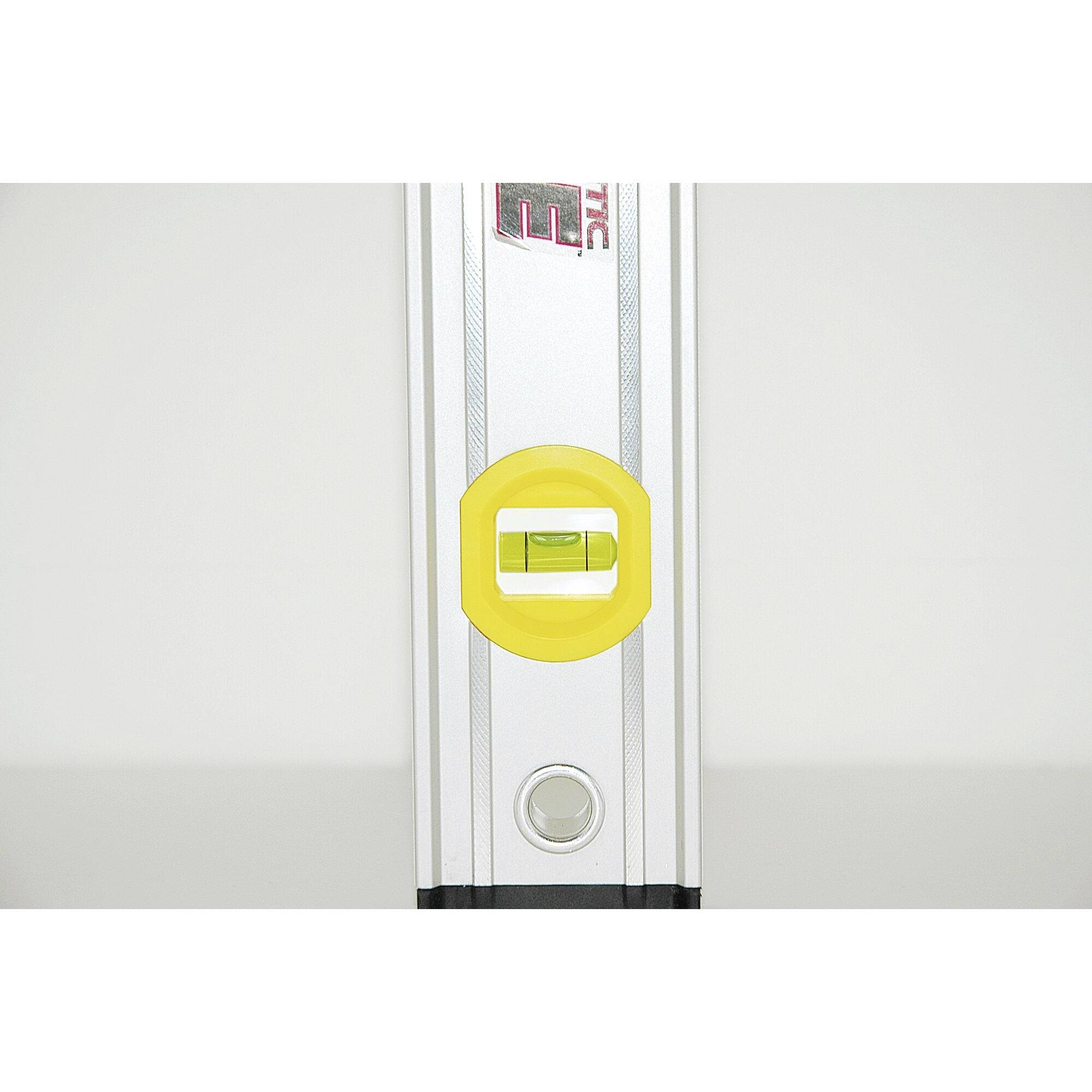 Vodováha s nápadnou žlutou libelou a šedým pouzdrem, umístěná uprostřed.