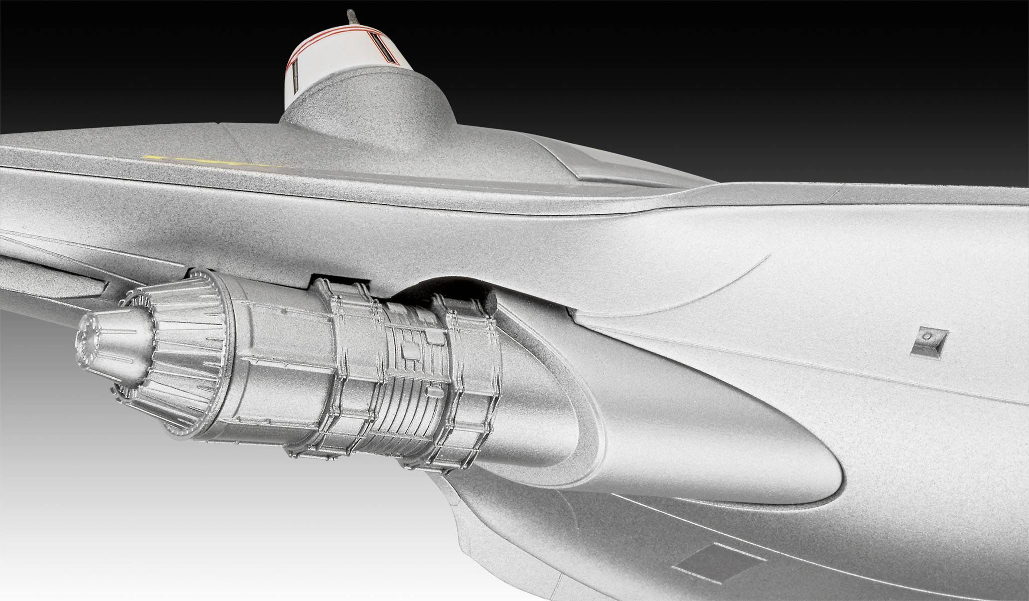 Detailní pohled na stříbrný letecký motor na futuristickém letadle. Jsou patrné hladké, aerodynamické povrchy.