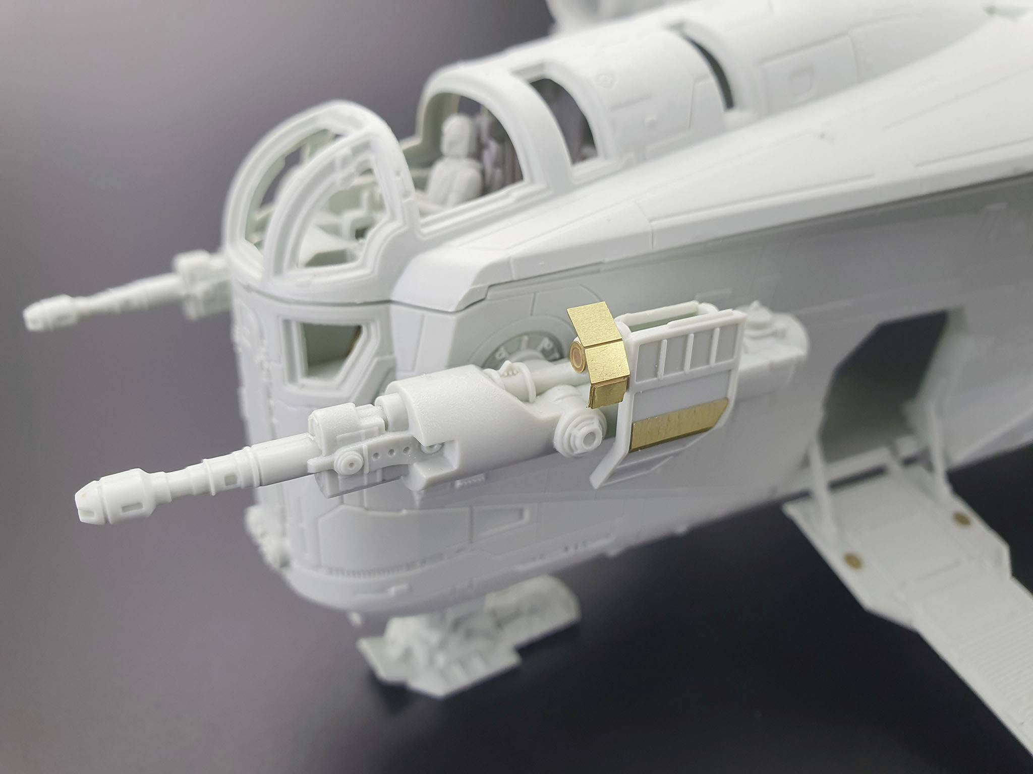 Detailní záběr plastikového modelu futuristického letadla s komplexní strukturou a hlavněmi zbraní.