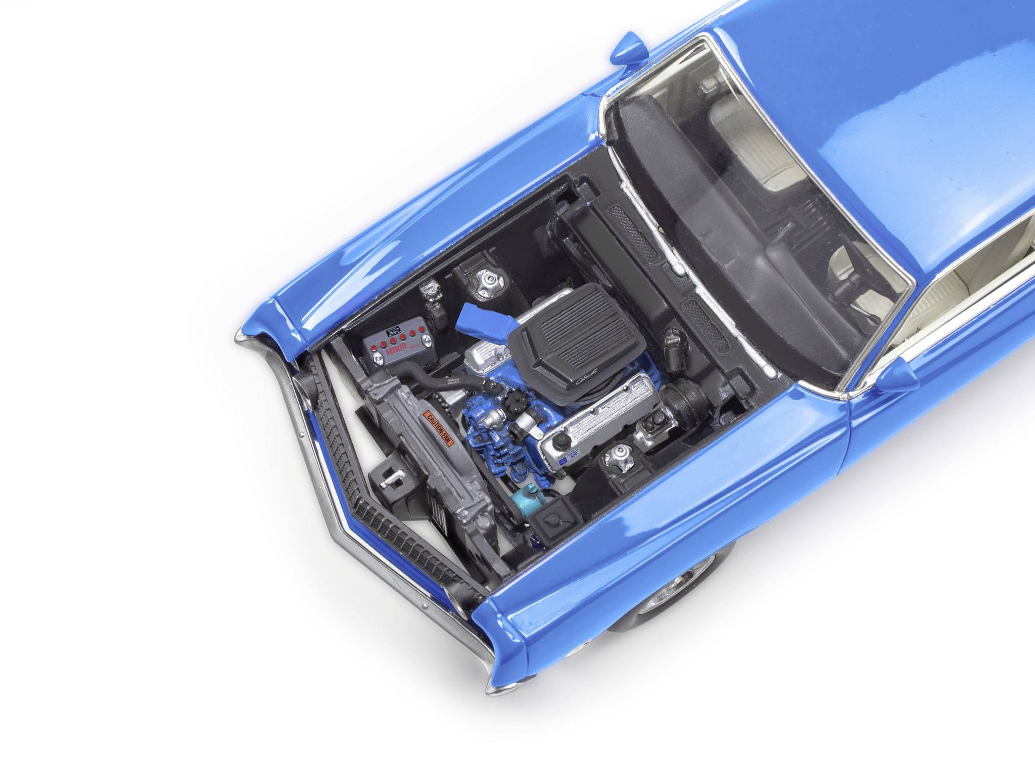 Modrý veterán s otevřenou kapotou motoru odhaluje detailně prostor motoru a jeho komponenty.