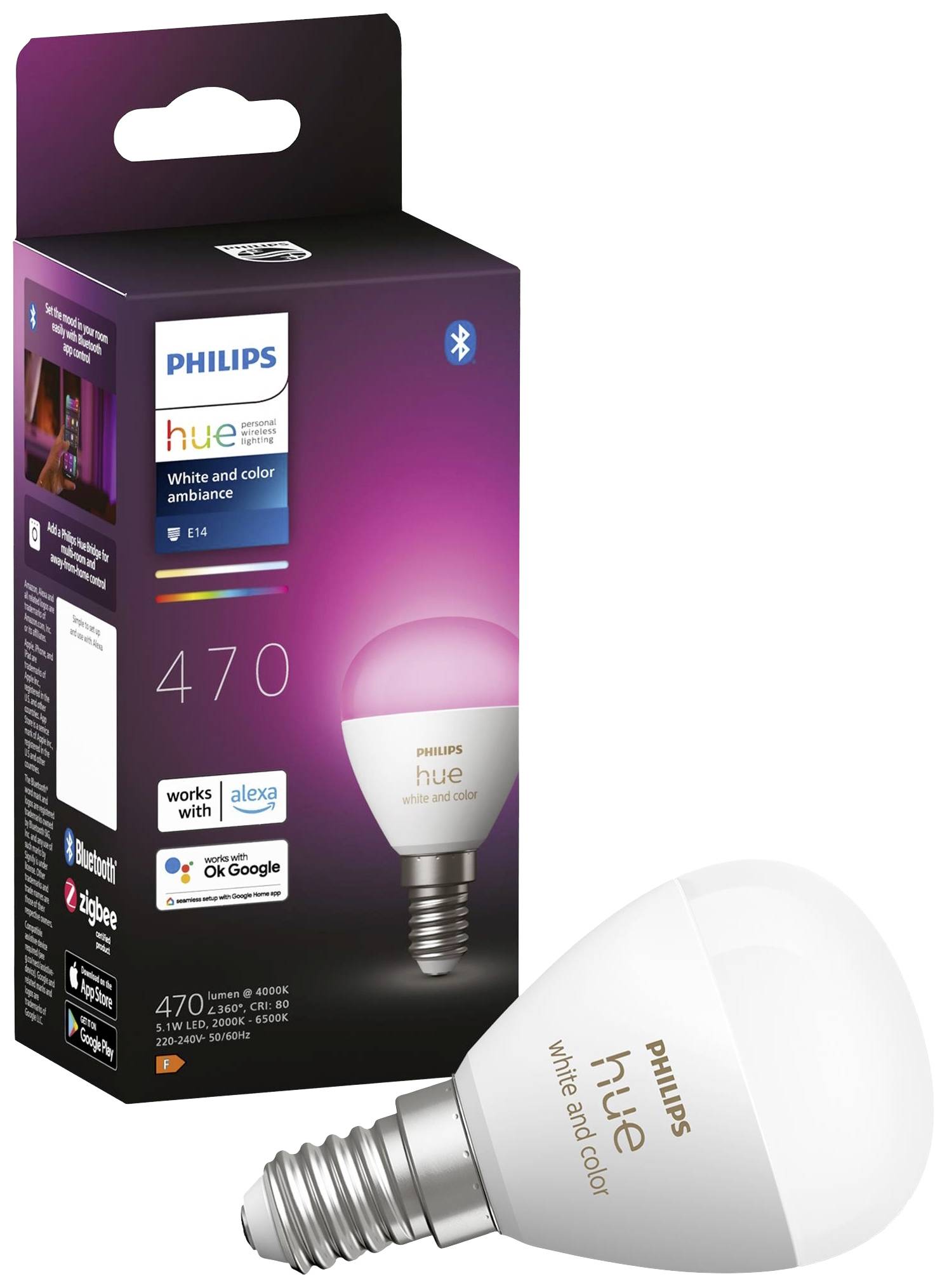Barevná LED žárovka Philips Hue vedle jejího obalu. Žárovka je vhodná pro bílé i barevné osvětlení. Obal ukazuje kompatibilitu s hlasovými asistenty.