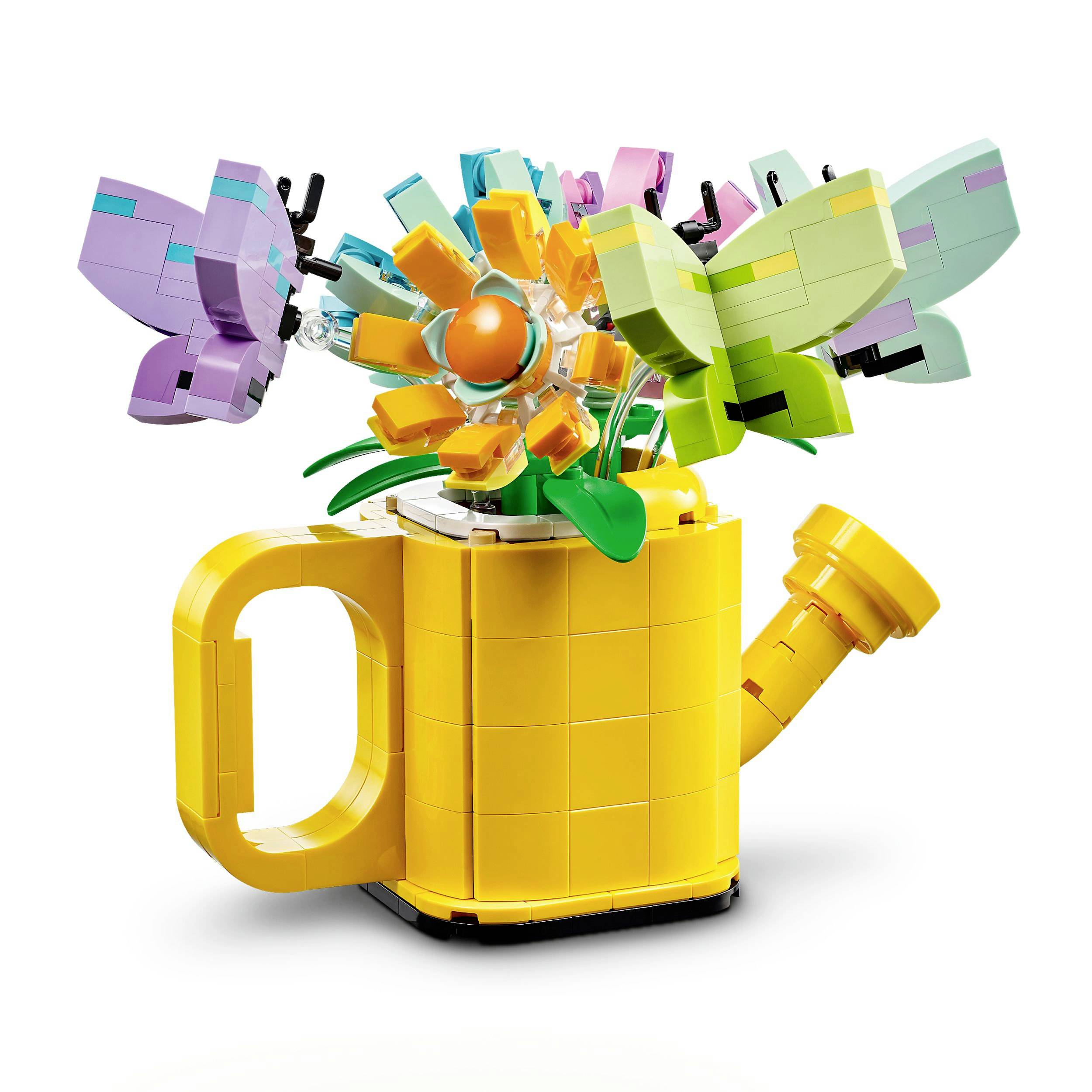 Barevná LEGO konvička, z níž vyrůstá živoucí květ s pestrobarevnými okvětními lístky a dva motýli.