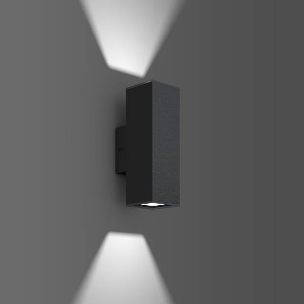 Černá nástěnná lampa svítí nahoru a dolů a vytváří světelný kužel na šedé stěně.