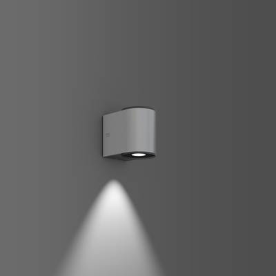 Nástěnné svítidlo s moderním, minimalistickým designem dopadá dolů na šedou stěnu. Klidné, elegantní osvětlení.