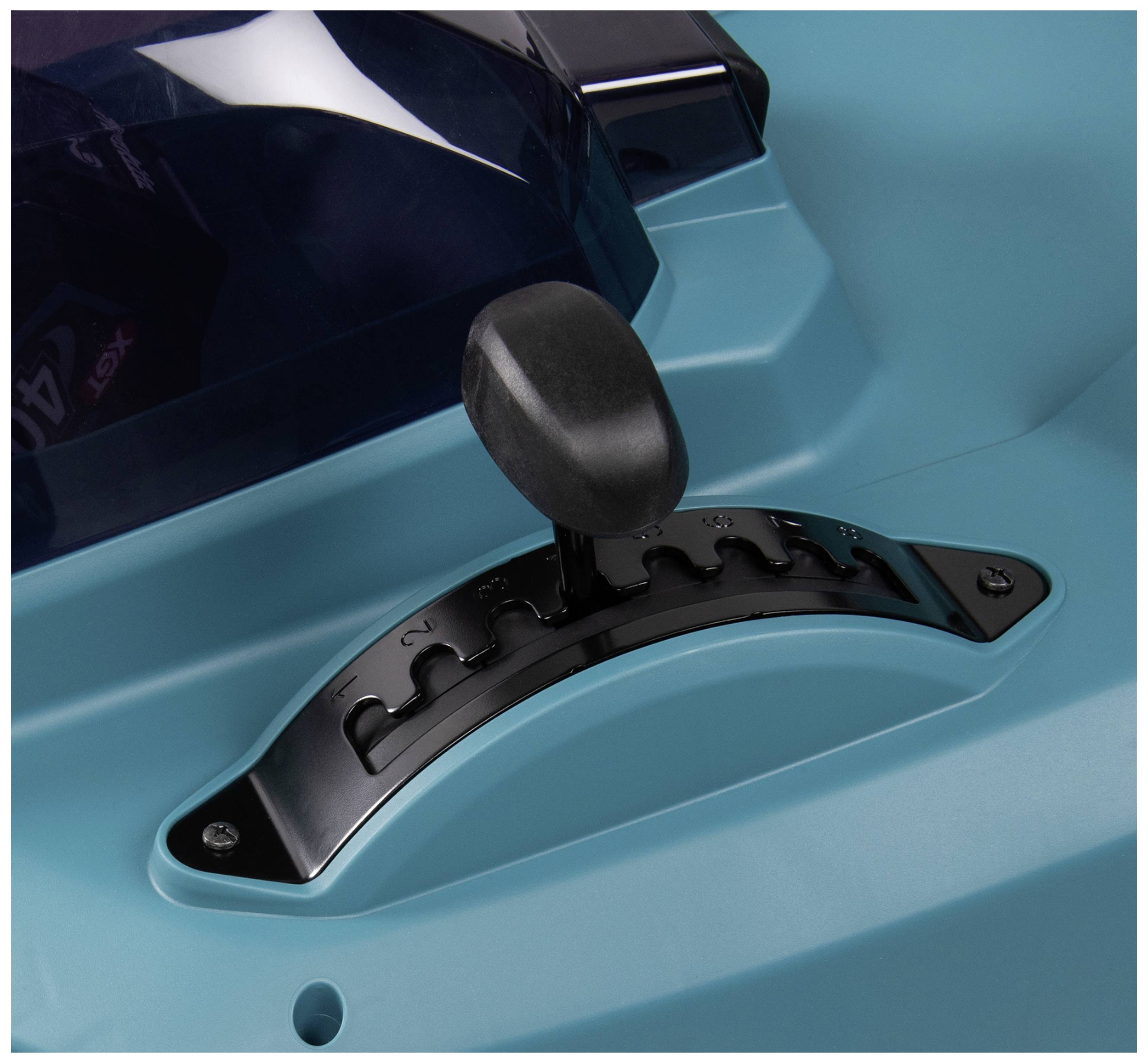 Detailní záběr páky na stroji s modným krytem, která se dá nastavit do různých poloh.