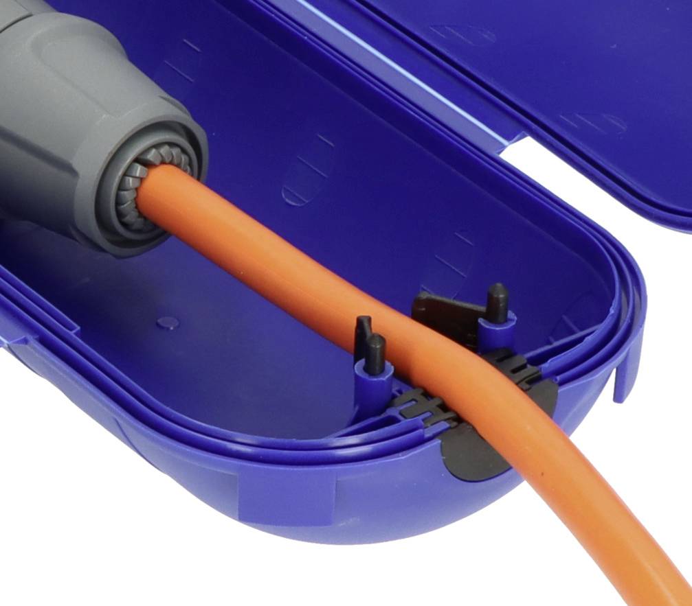Oranžový kabel je veden do modré ochranné krabice. Krabice chrání kabelové spoje před povětrnostními vlivy.