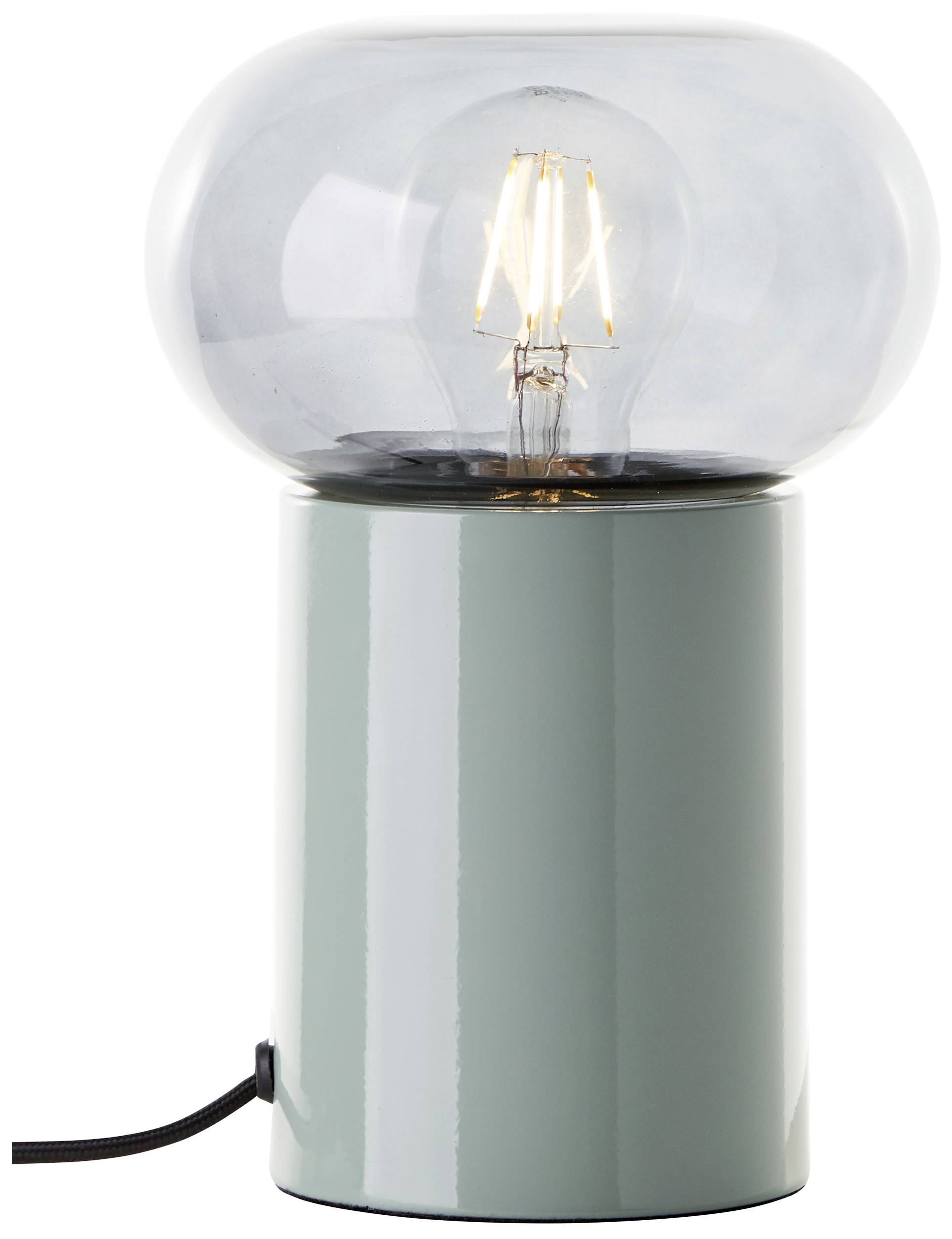 Stolní lampa s průhledným sklem a viditelnou žárovkou umístěná na kovovém podstavci. Ideální pro moderní interiérový design.