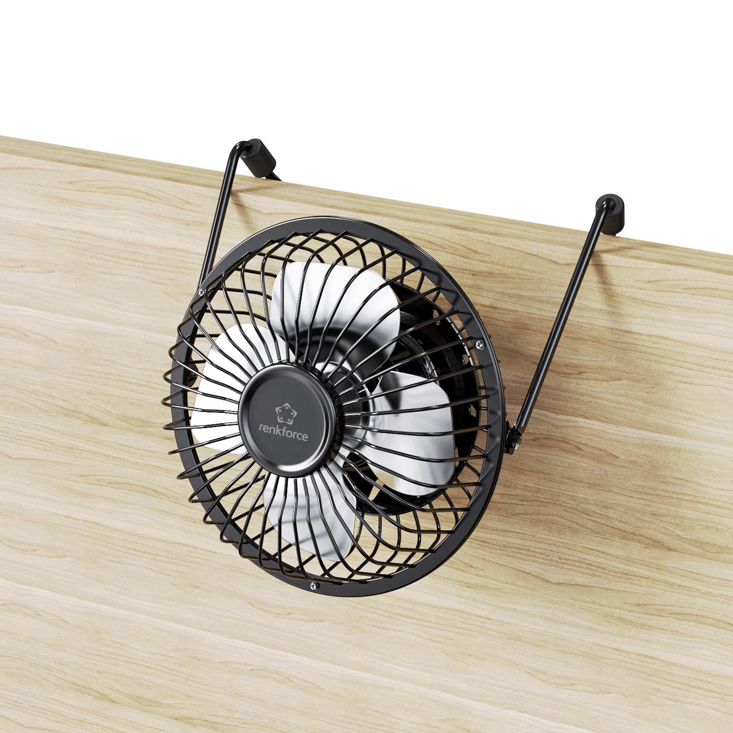 Malý černý ventilátor je připevněn k dřevěné desce stolu. Ventilátor má pět stříbrných rotorových listů.