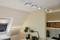 Kuchyně se šikmým dřevěným stropem, moderním bodovým osvětlením, psacím stolem s rostlinami a knihami. Světlá, útulná atmosféra.