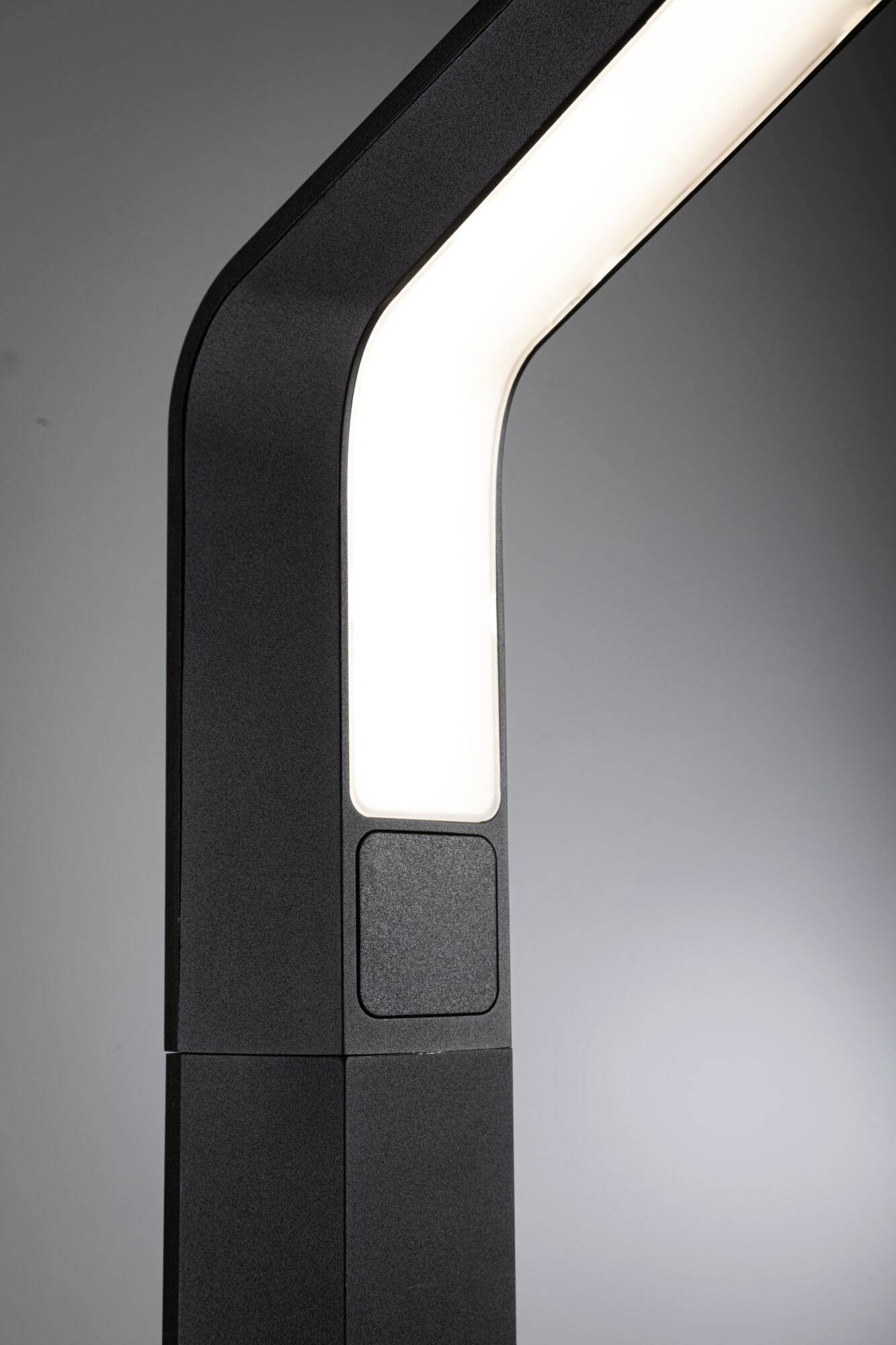 Černý, zahnutý krk lampy s jasným bílým světelným pruhem. Moderní design na šedém pozadí.