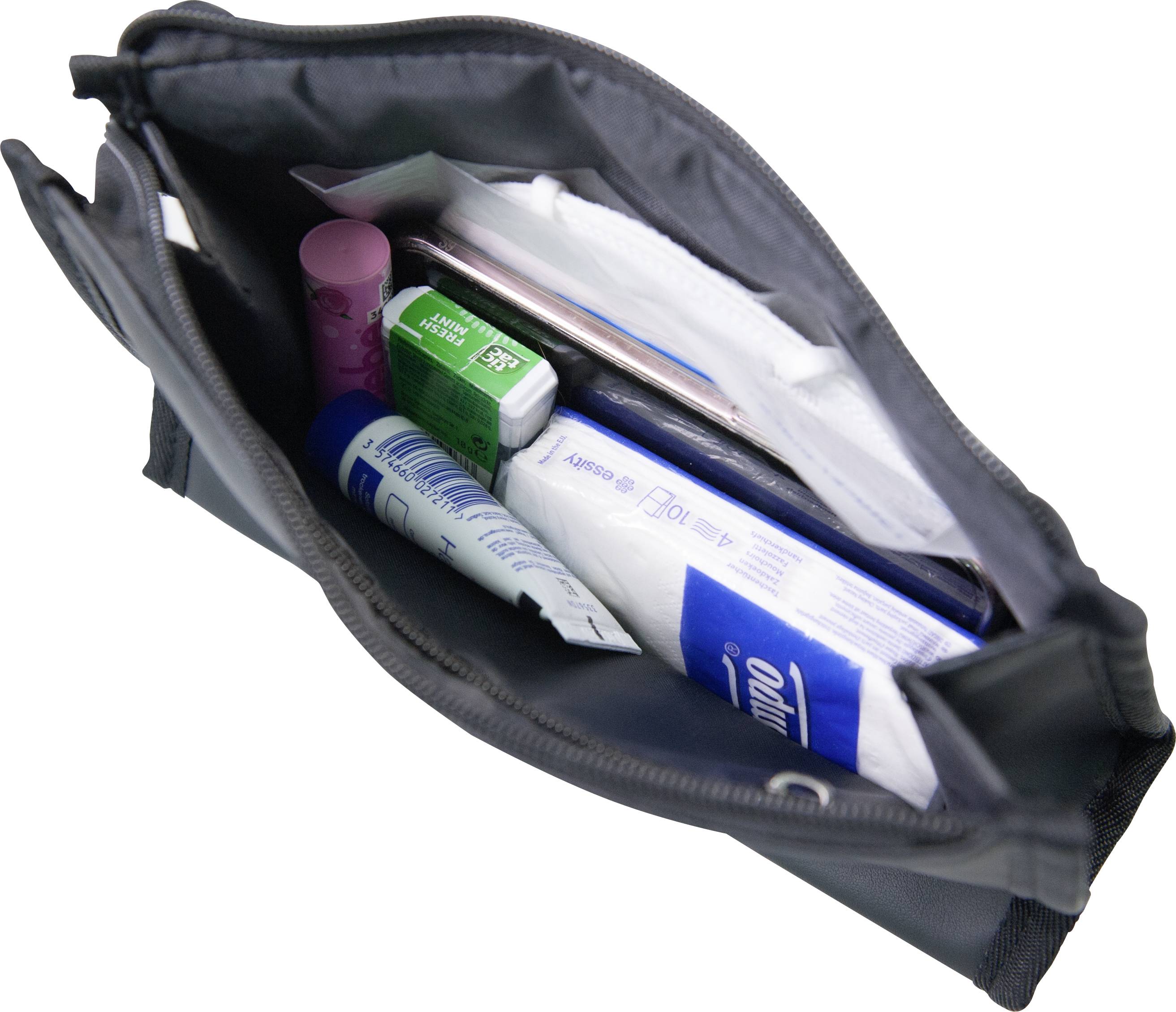 Otevřená taška s hygienickými potřebami: zubní pasta, ústní voda, balzám na rty, papírové kapesníky a zubní kartáček.
