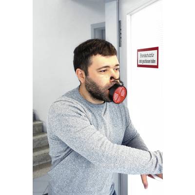 Muž v respirátoru otevírá protipožární dveře s nápisem 'Protipožární dveře udržujte vždy zavřené'.