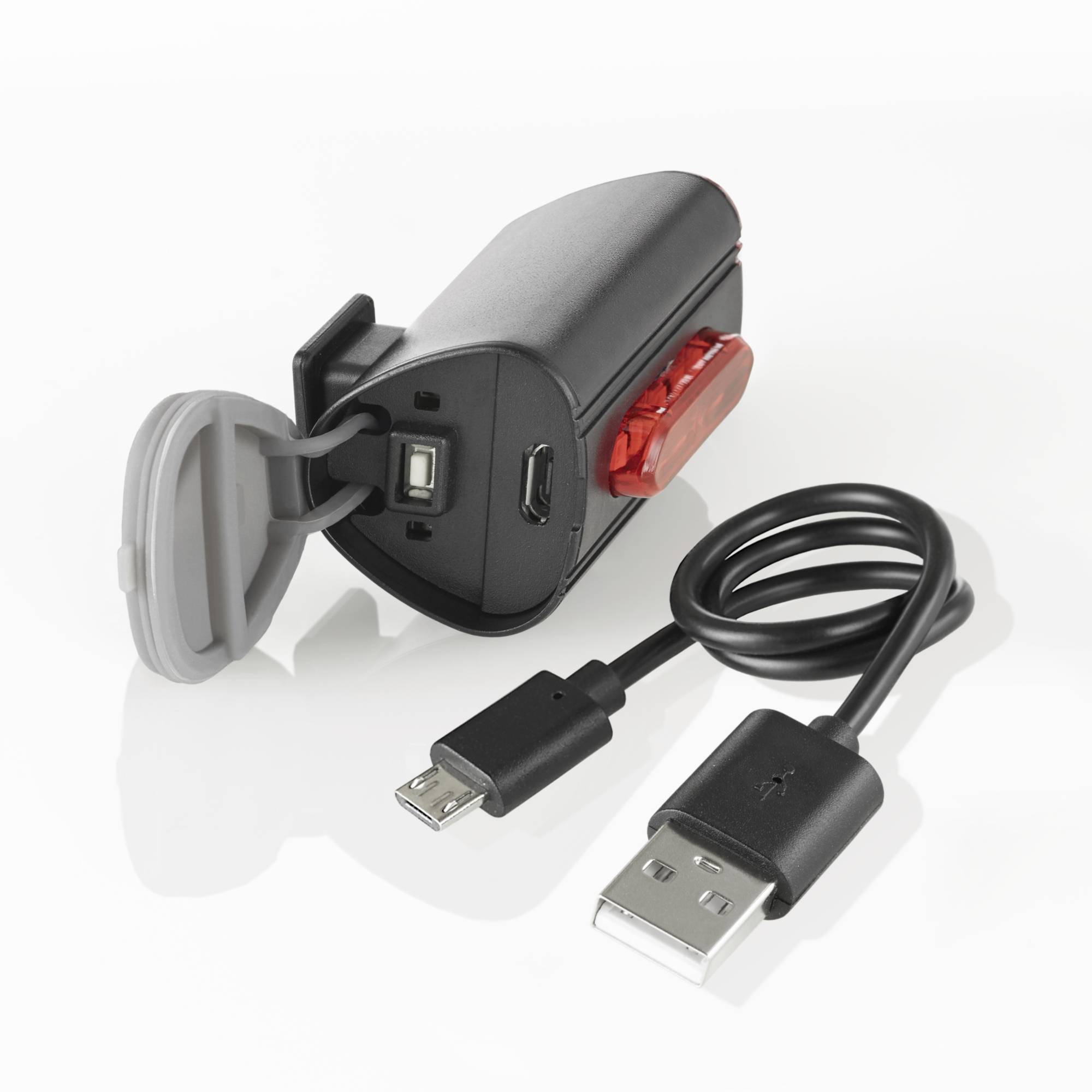 Přenosná nabíječka s USB portem a odpojitelným USB kabelem, vhodná pro mobilní nabíjení.