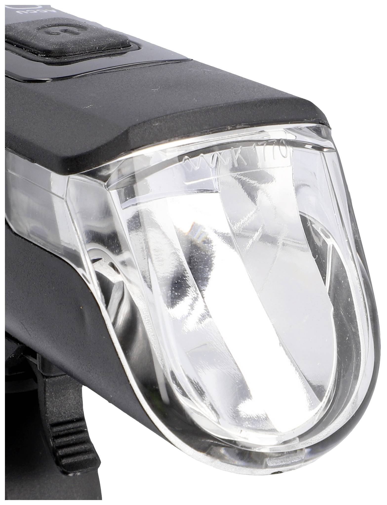Cyklistická lampa v detailním záběru, ukazující čiré, lehce zakřivené sklo a LED diodu uvnitř.
