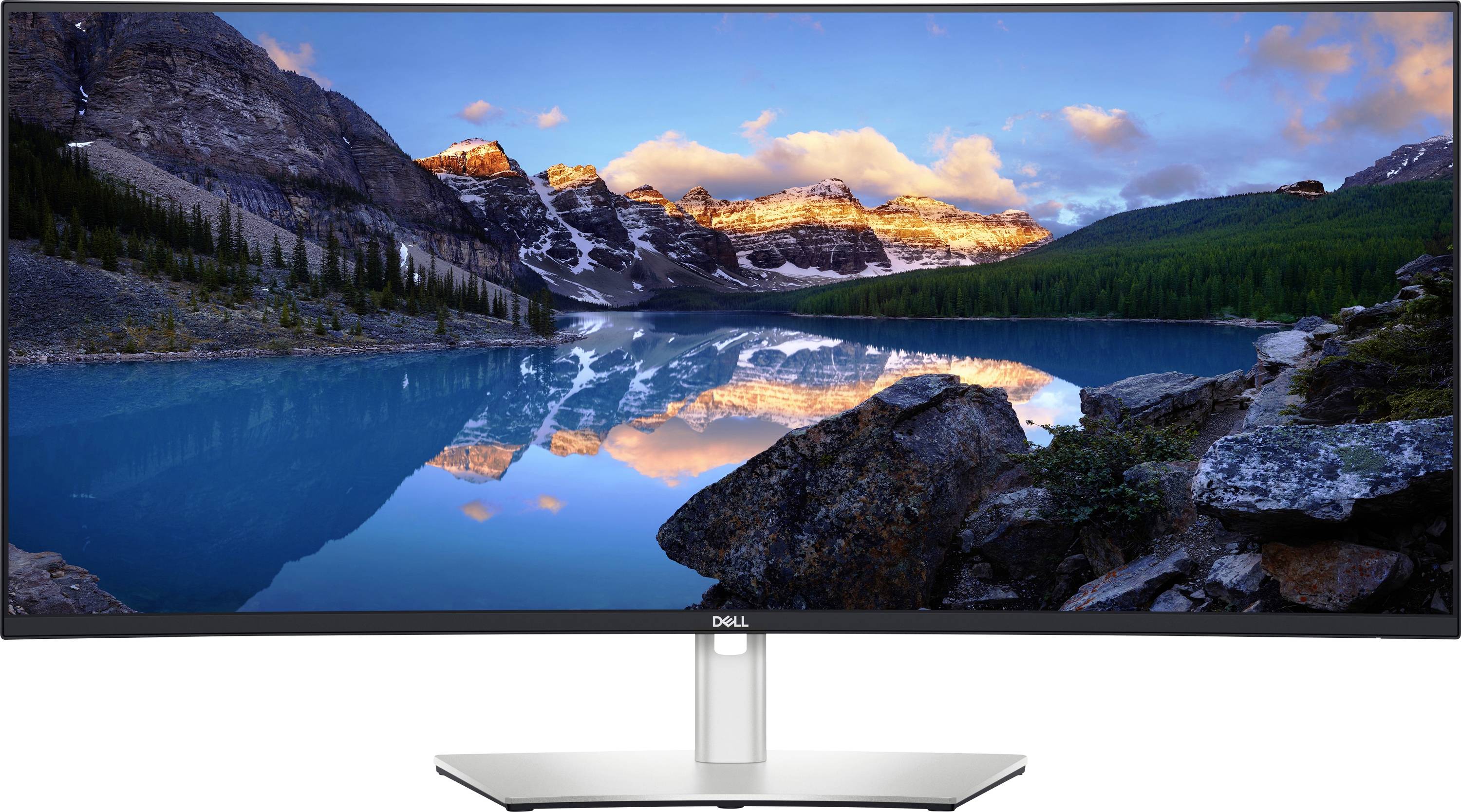 Monitor Dell zobrazující malebnou horskou krajinu s jezerem odrážejícím horské štíty osvětlené západem slunce a jasnou modrou oblohou.