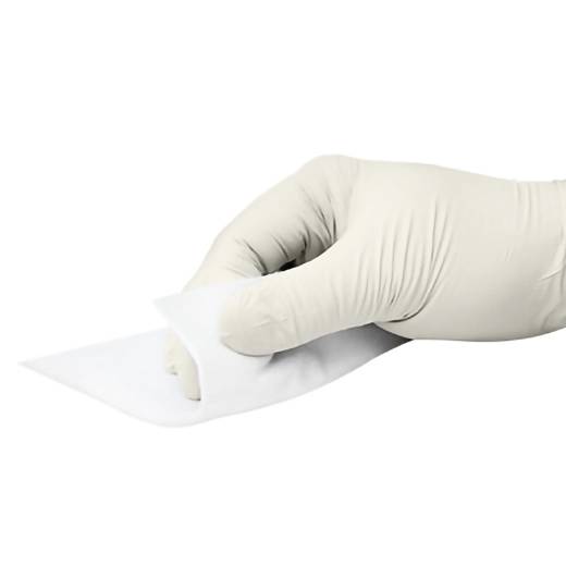 Rukavicí obalovaná ruka odlepuje bílou samolepicí náplast nebo lékařský obvaz na bílém pozadí.
