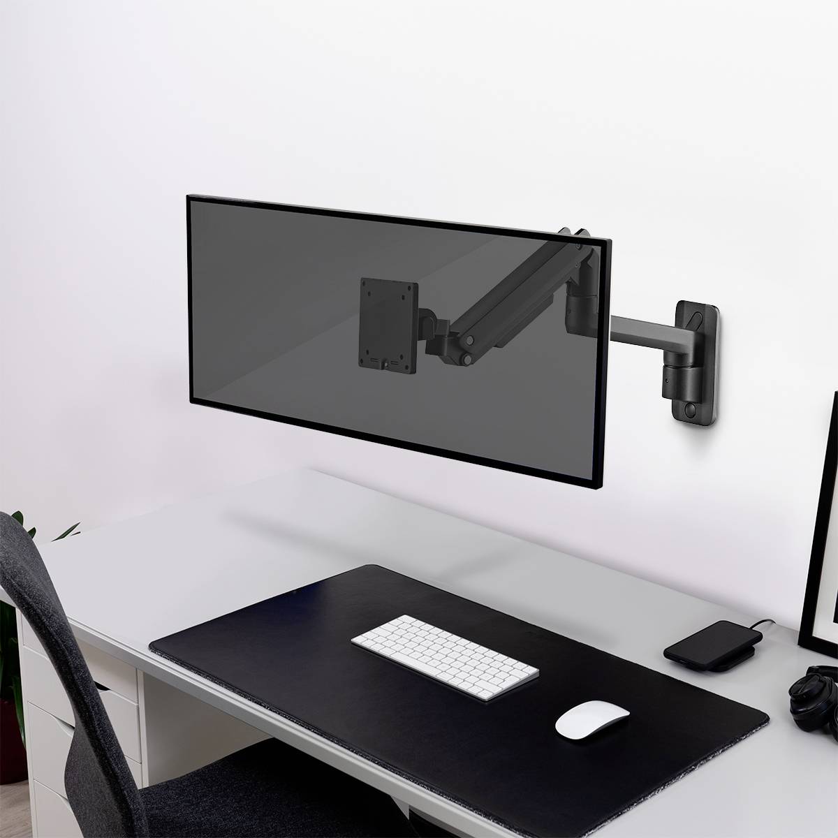 Čistý psací stůl s klávesnicí, myší a monitorovým ramenem bez monitoru, vše v moderním a minimalistickém designu.