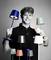 Muž se smíchem drží v obou rukách několik barevných stolních lamp. Lampy jsou moderně navržené a v různých barvách.