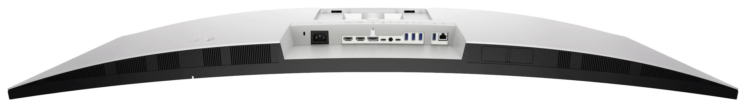 Pohled zezadu na zakřivený počítačový monitor s několika připojovacími porty, včetně HDMI, USB a napájecího konektoru.
