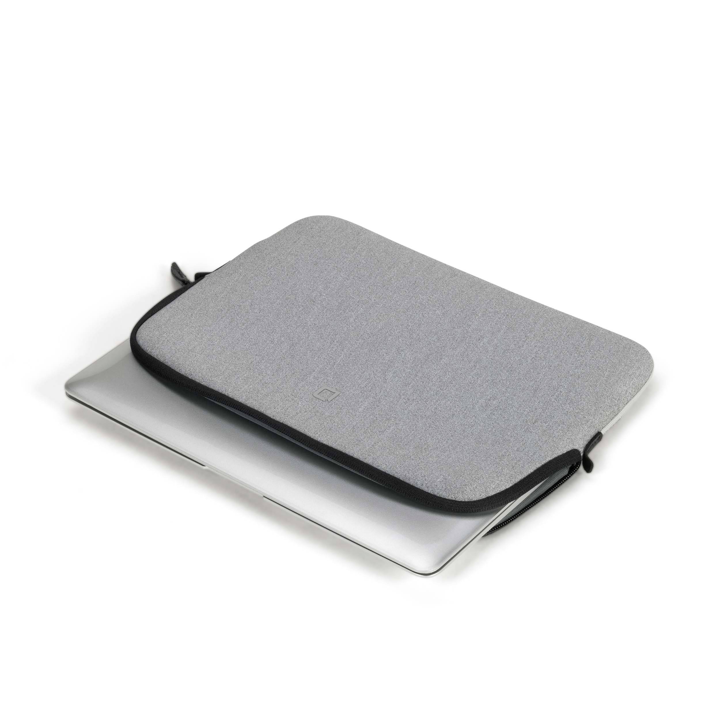 Látková šedá brašna na notebook leží na částečně viditelném stříbrném notebooku na bílém pozadí.