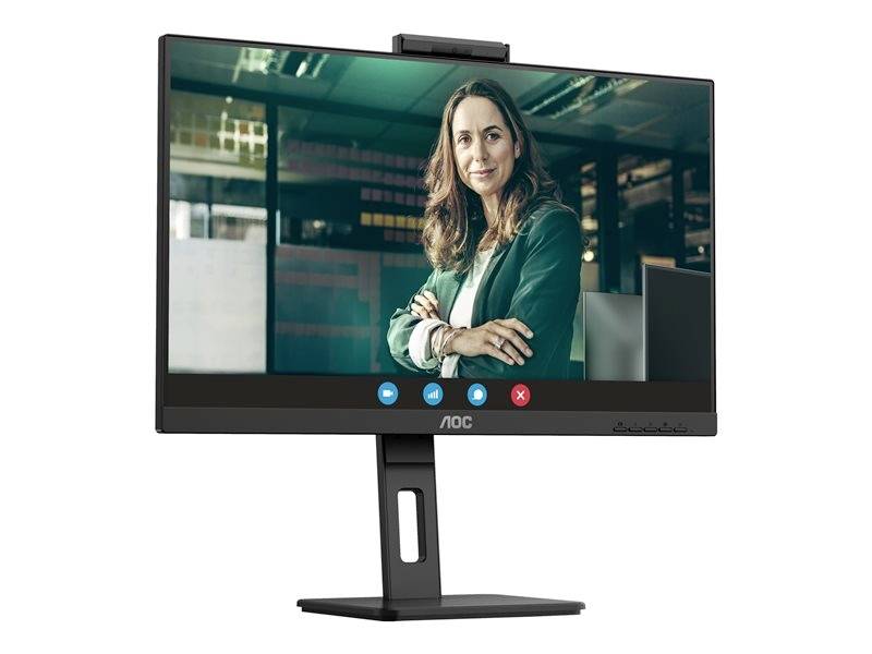 Žena v zeleném saku se usmívá během videokonference. Objevuje se na monitoru počítače v kanceláři.