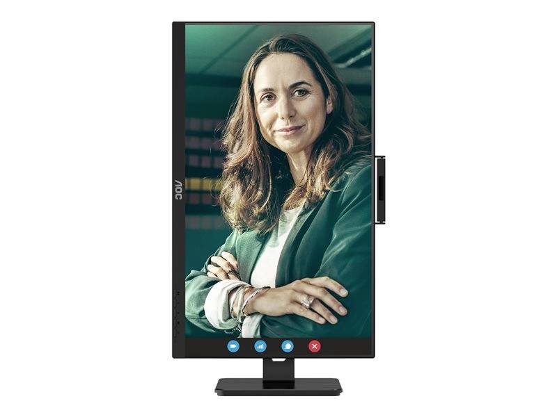 Žena s úsměvem během videohovoru, zobrazená na vertikálně orientovaném monitoru. Má na sobě zelené sako.