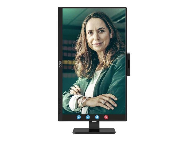 Osoba s kudrnatými vlasy se usmívá do kamery, stojící před rozmazaným pozadím v prostředí videohovoru.