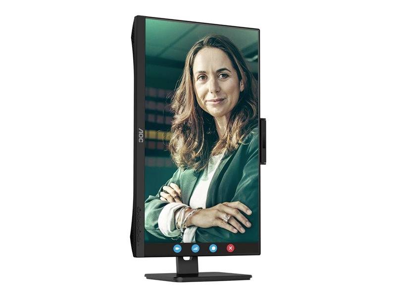Monitor s vertikálním displejem zobrazuje usměvavou ženu v zeleném saku. Dole jsou viditelné ikony možností videohovoru.