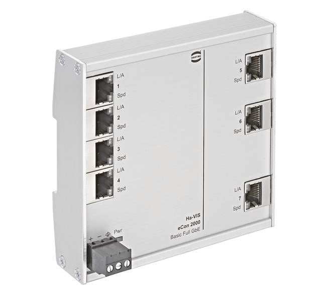 Stříbrný ethernetový switch s osmi RJ-45 porty, očíslovanými od 1 do 8. Vlevo dole malý černý napájecí konektor.